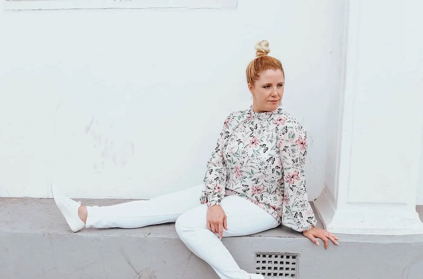 Rebecca Page sitting against a white wall