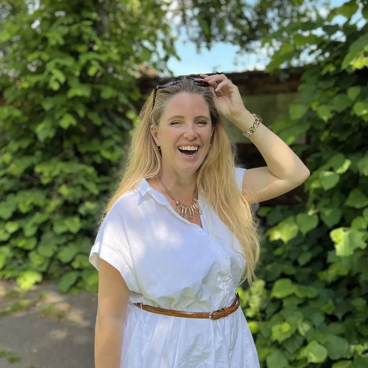 Rebecca Page laughing in a white dress