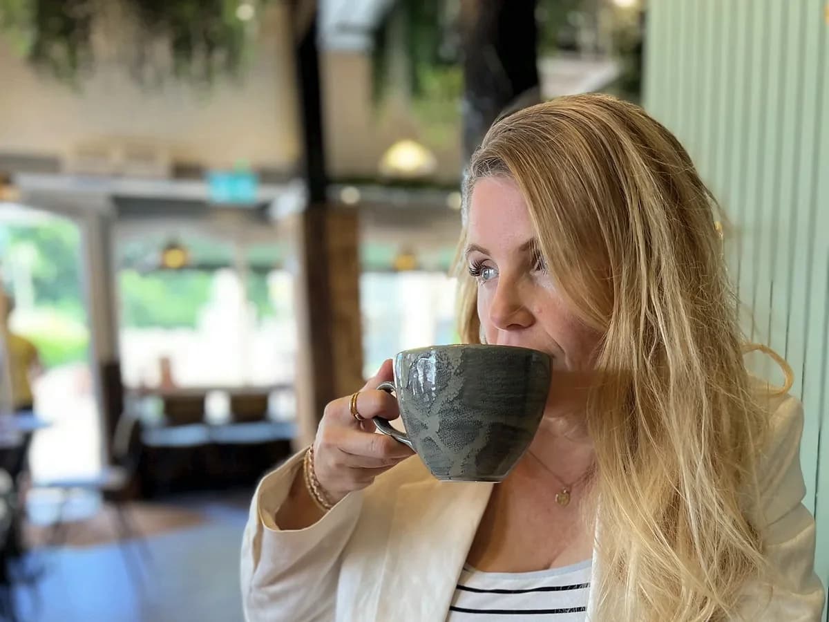 Rebecca Page smiling at a table in a grand dining room